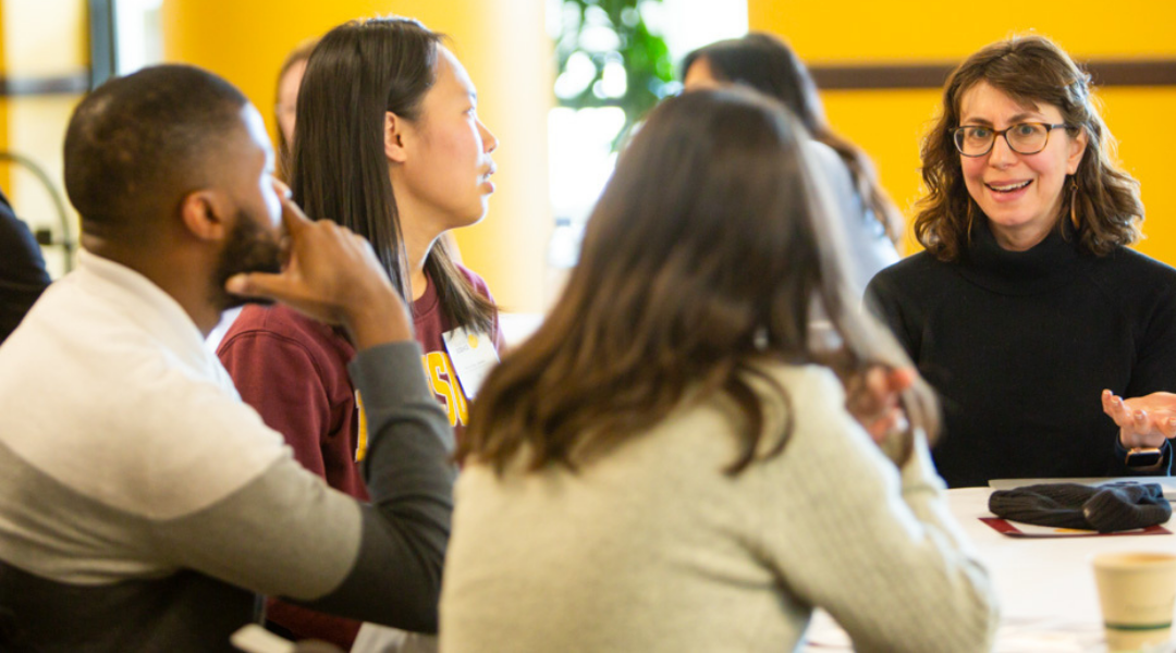 Speaking Science attendees chat at a table.